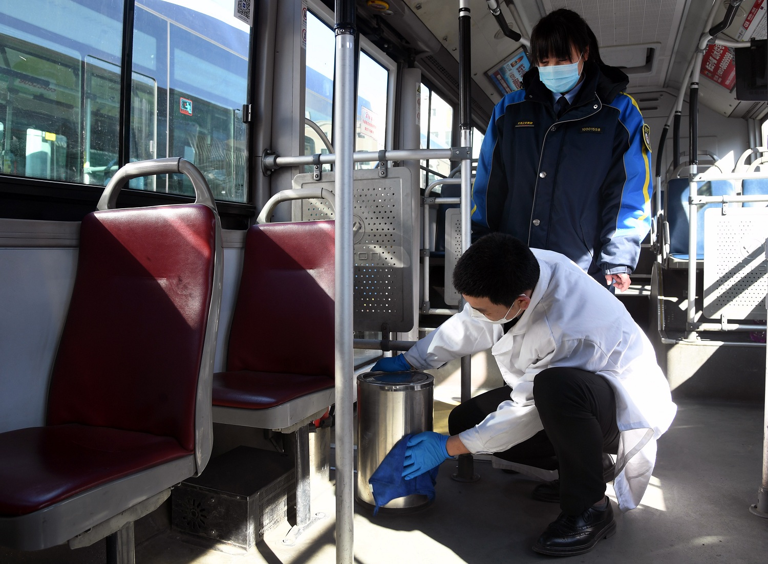 Bus driver Li Tengfei front disinfects the garbage can on the bus